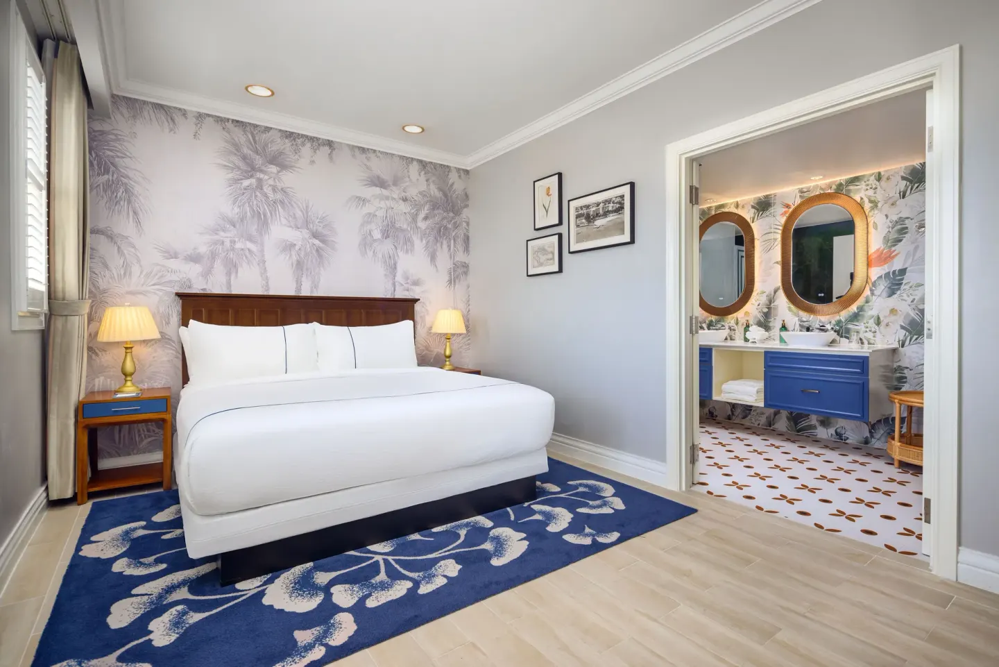 Guest room with a king bed and open blue vanity bathroom at British Colonial Nassau.
