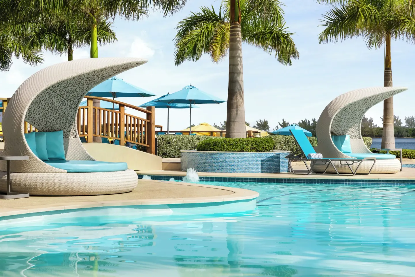 Poolside daybeds with curved white canopies at British Colonial Nassau.