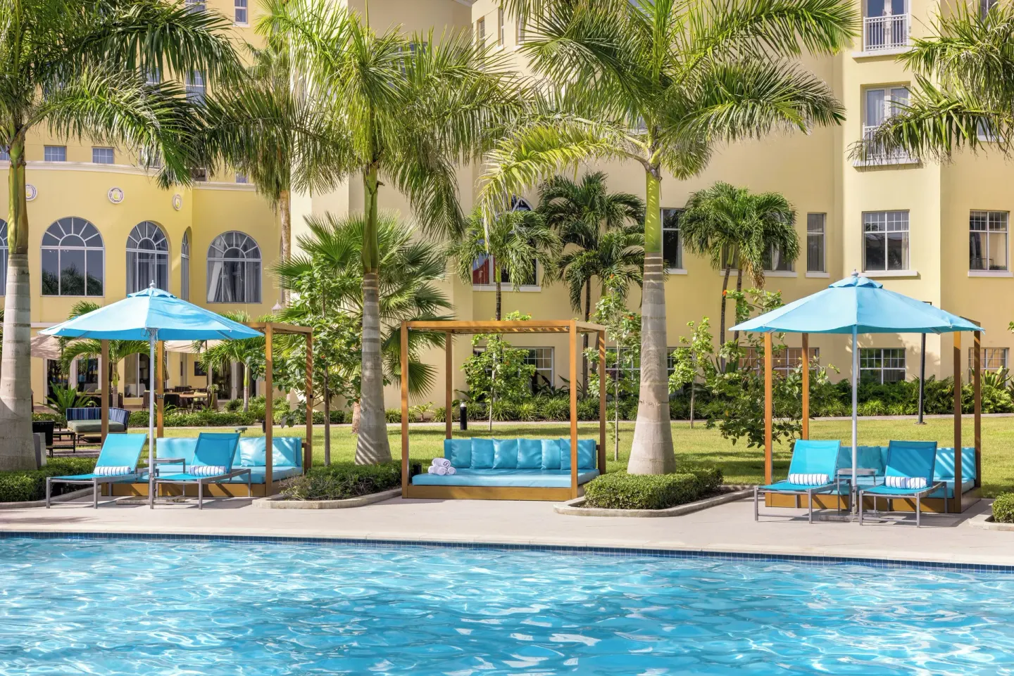 Poolside loungers and cabana seating among palms at British Colonial Nassau.