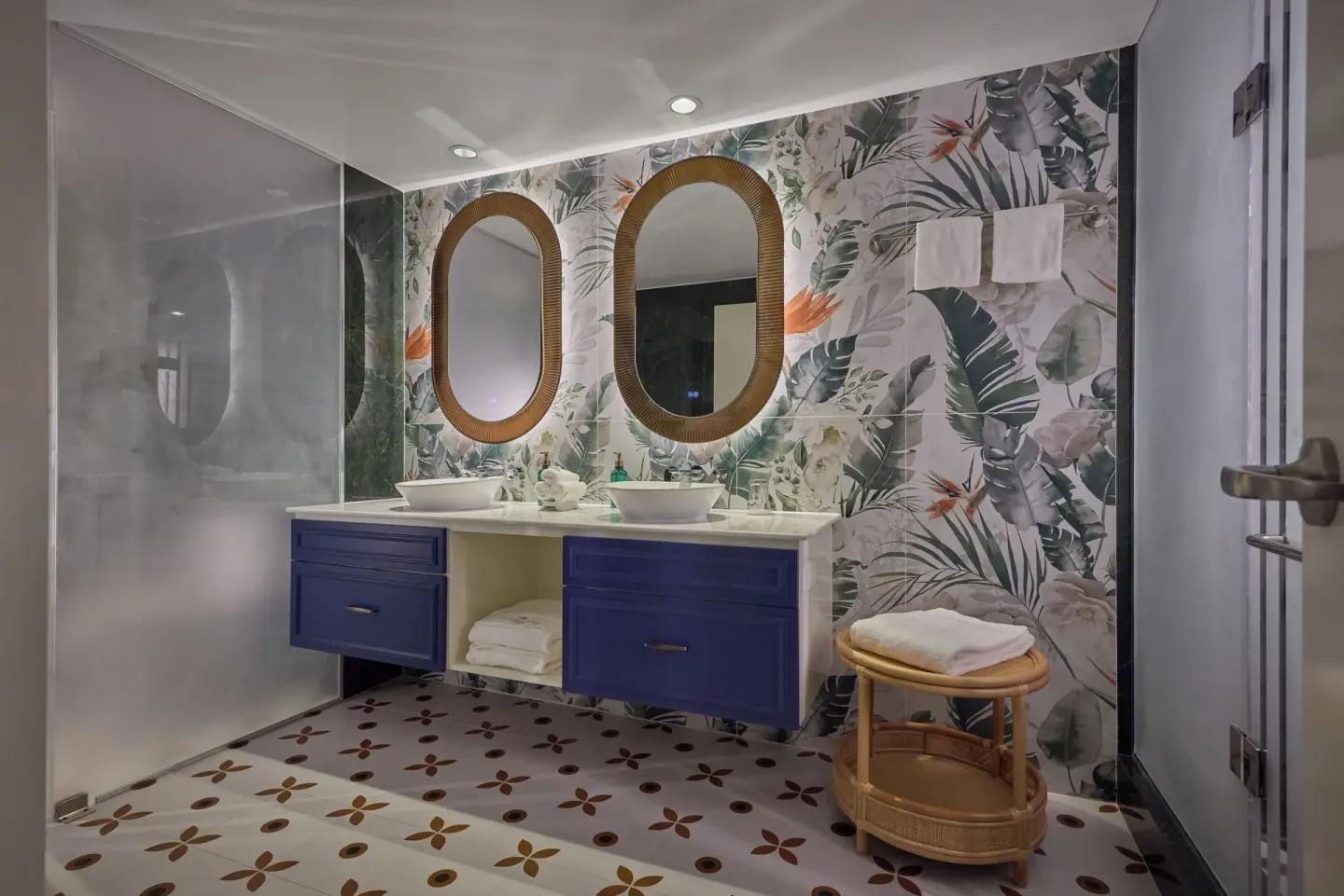 Tropical bathroom with twin sinks and round mirrors at British Colonial Nassau.