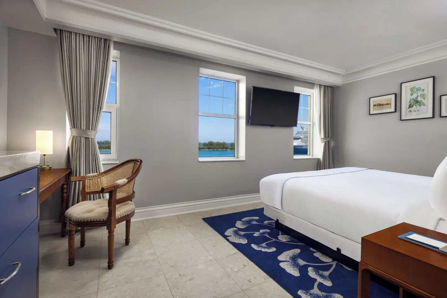 Ocean View room with one bed, wall-mounted TV, desk, and water views at British Colonial Nassau.