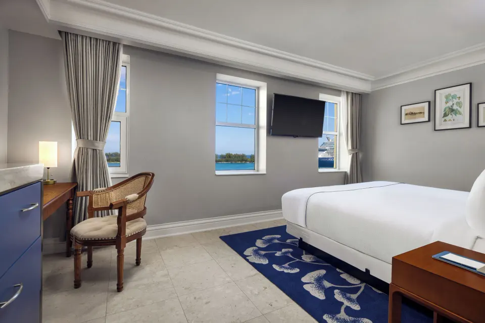 Ocean View room with one bed, wall-mounted TV, desk, and water views at British Colonial Nassau.