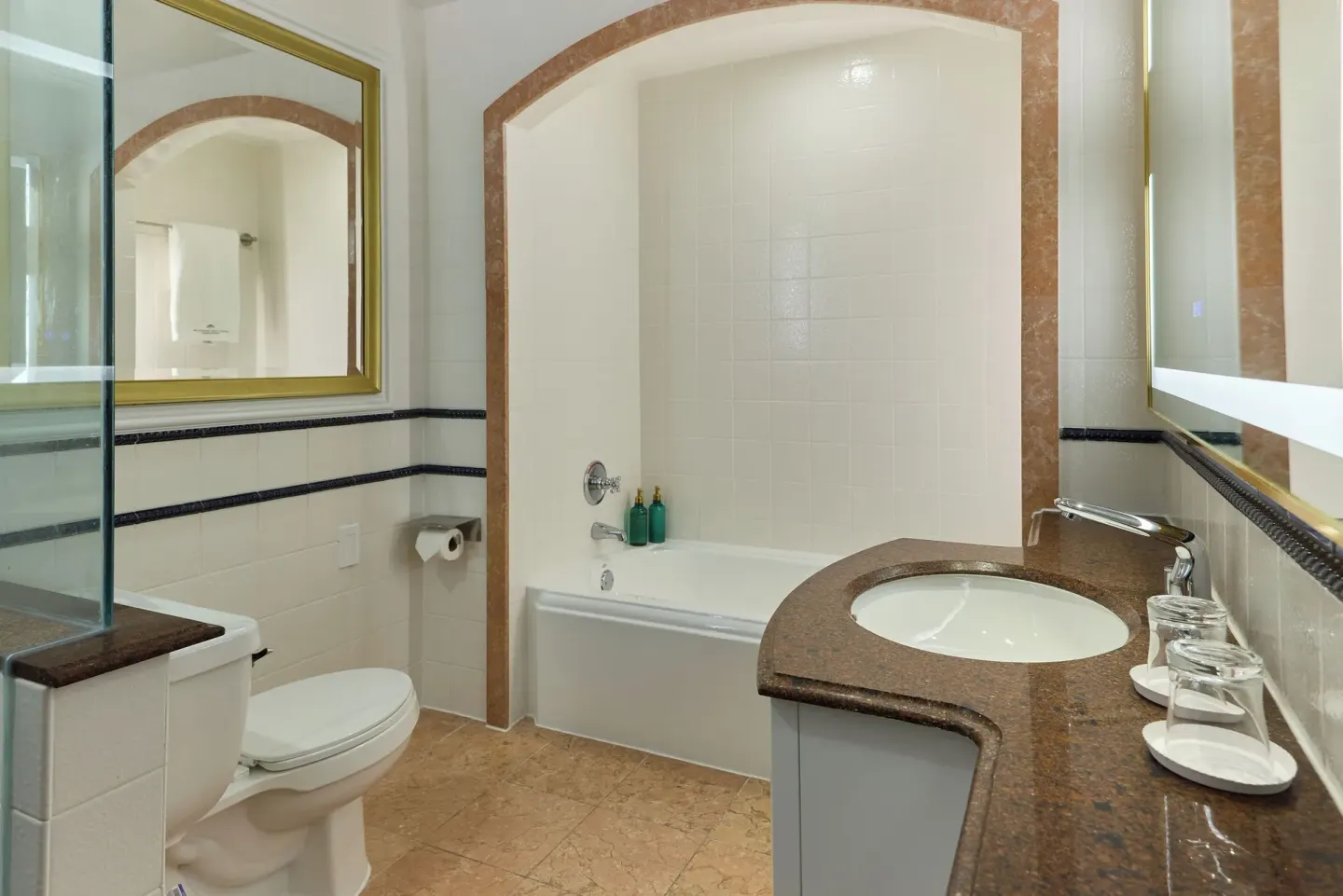 Standard Room bathroom with tub, vanity, toilet, and mirror at British Colonial Nassau.