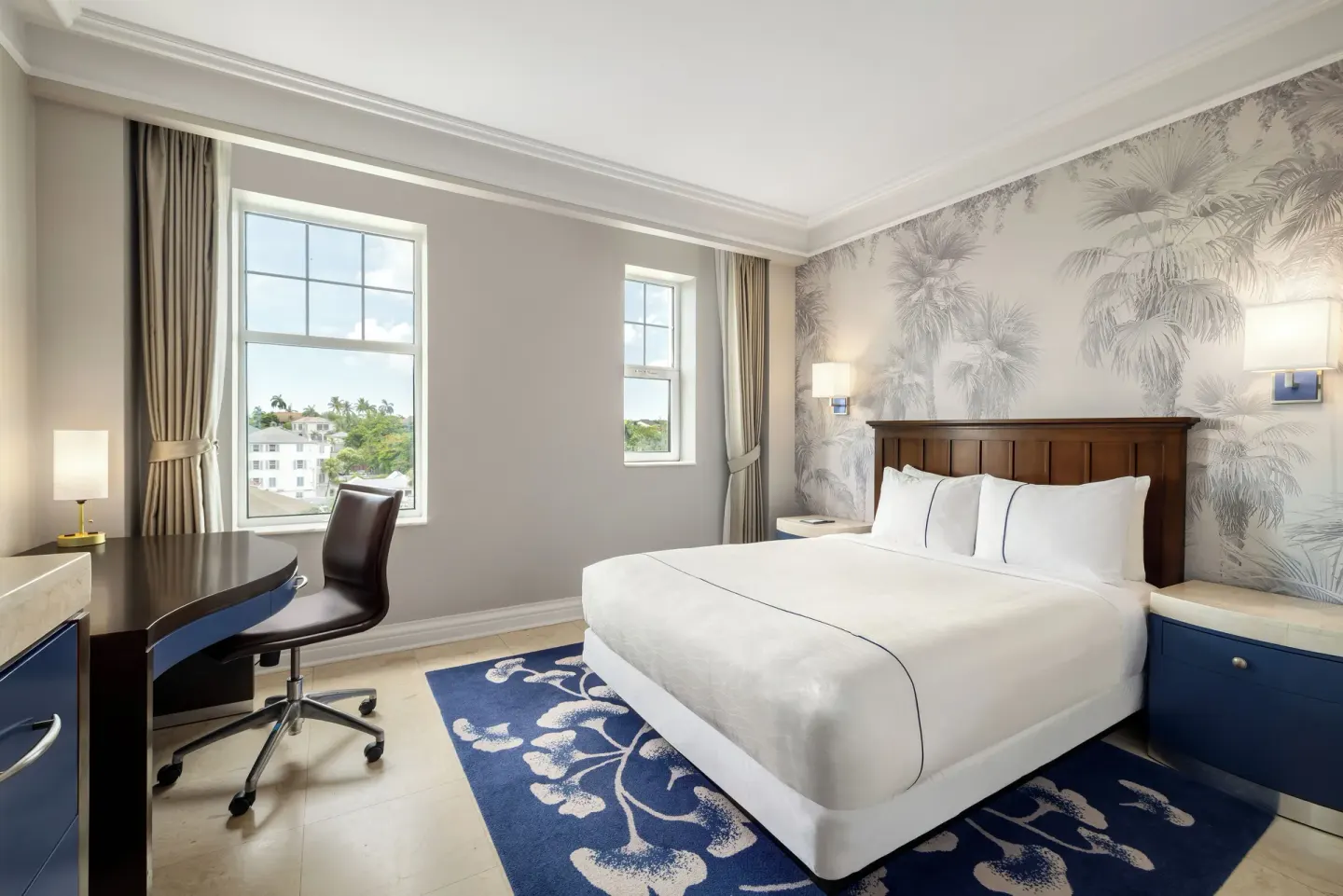 Standard Room king bed with desk and two windows at British Colonial Nassau.