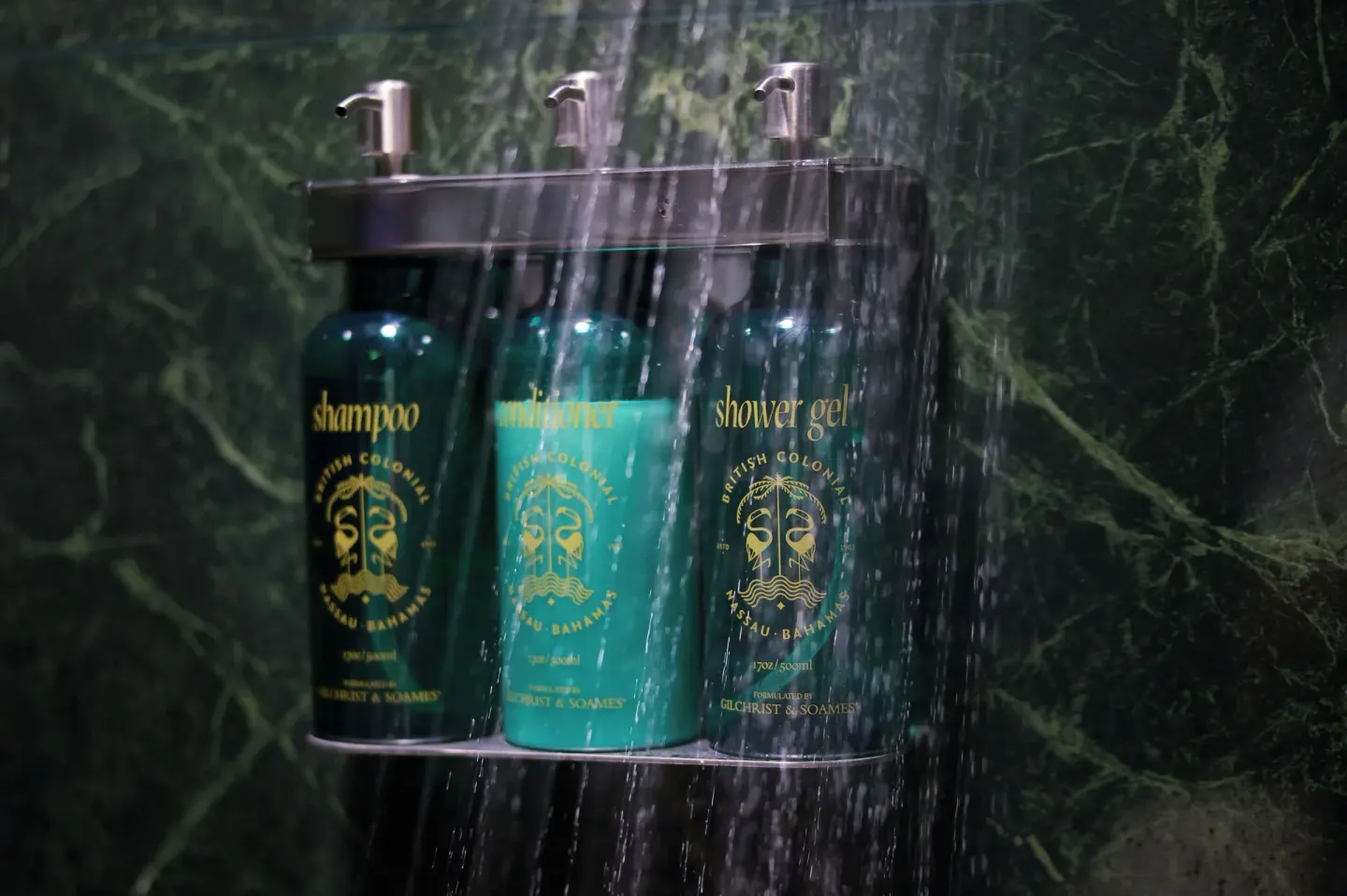 Standard Room shower amenities mounted on green stone wall at British Colonial Nassau.