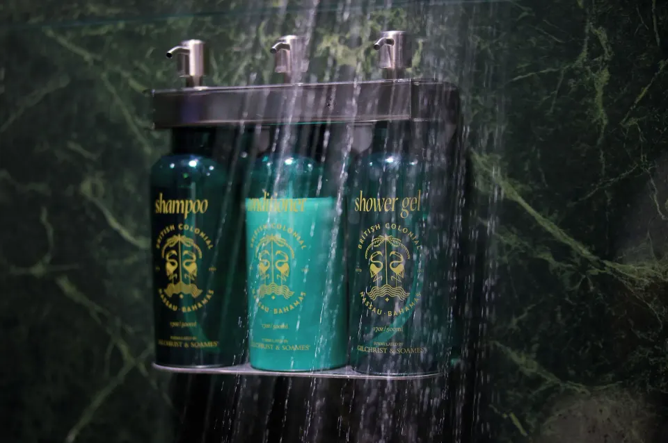 Standard Room shower amenities mounted on green stone wall at British Colonial Nassau.