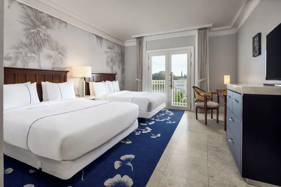 Standard Room with two queen beds and balcony doors at British Colonial Nassau.