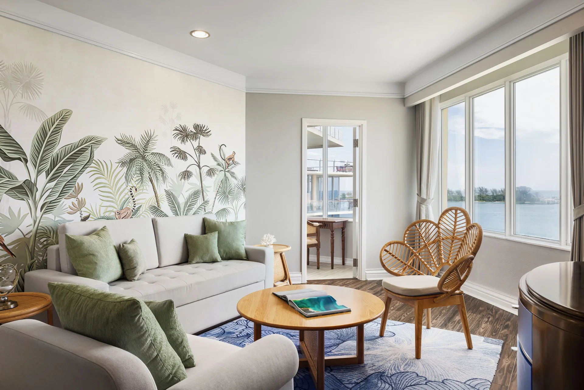 City View Suite living room with sofa, rattan chairs, and water views at British Colonial Nassau.