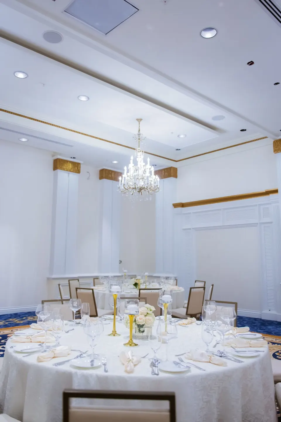 Round banquet tables under a chandelier at British Colonial Nassau.