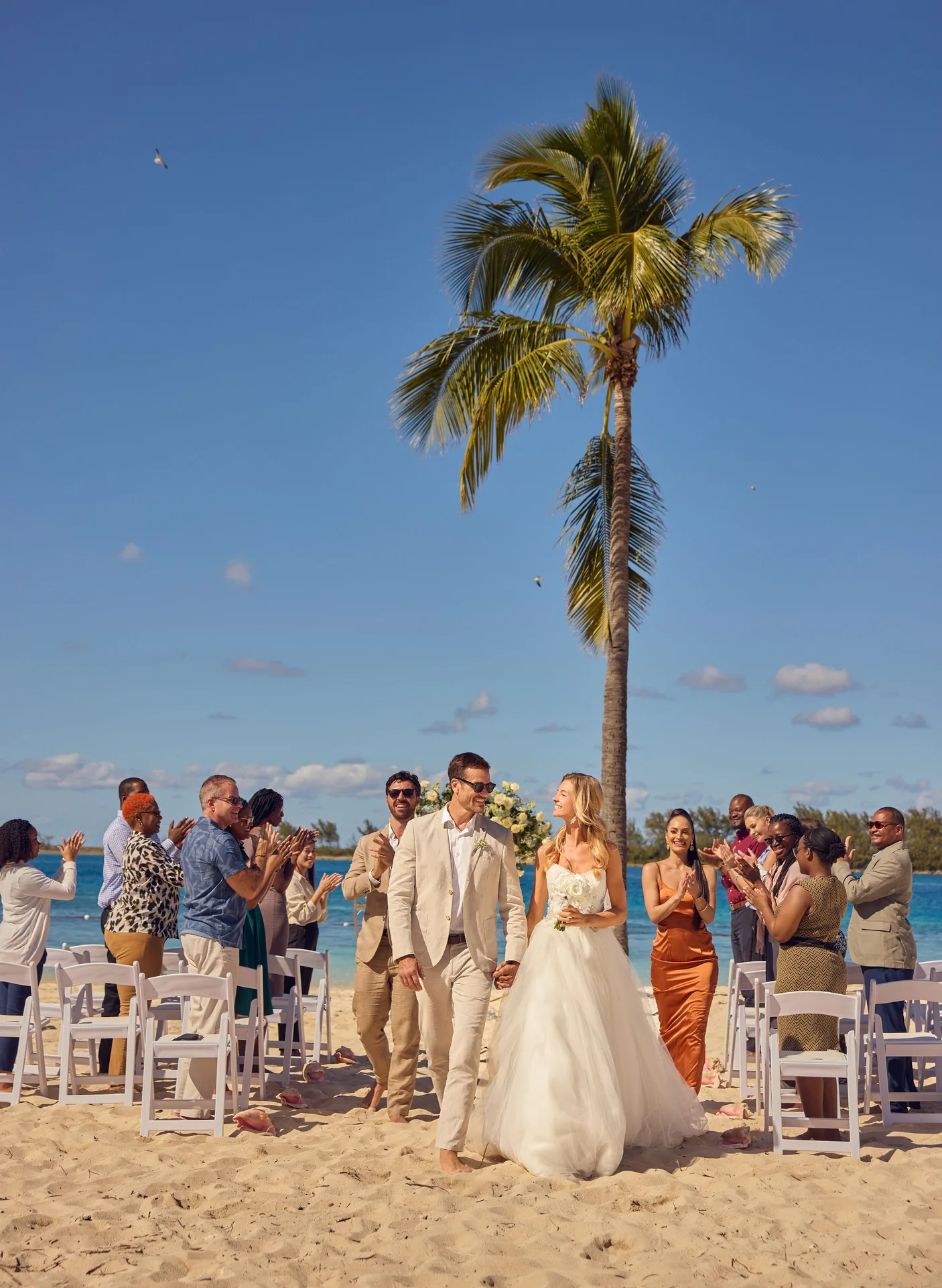 Beach wedding recessional under a palm tree at British Colonial Nassau.