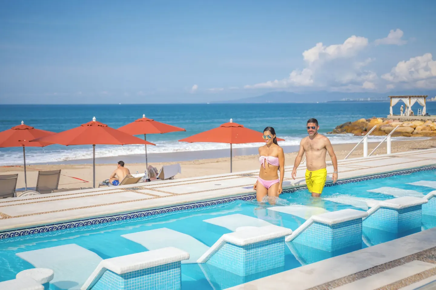 Guests wade in a beachfront pool at Buenaventura Grand Hotel & Great Moments.