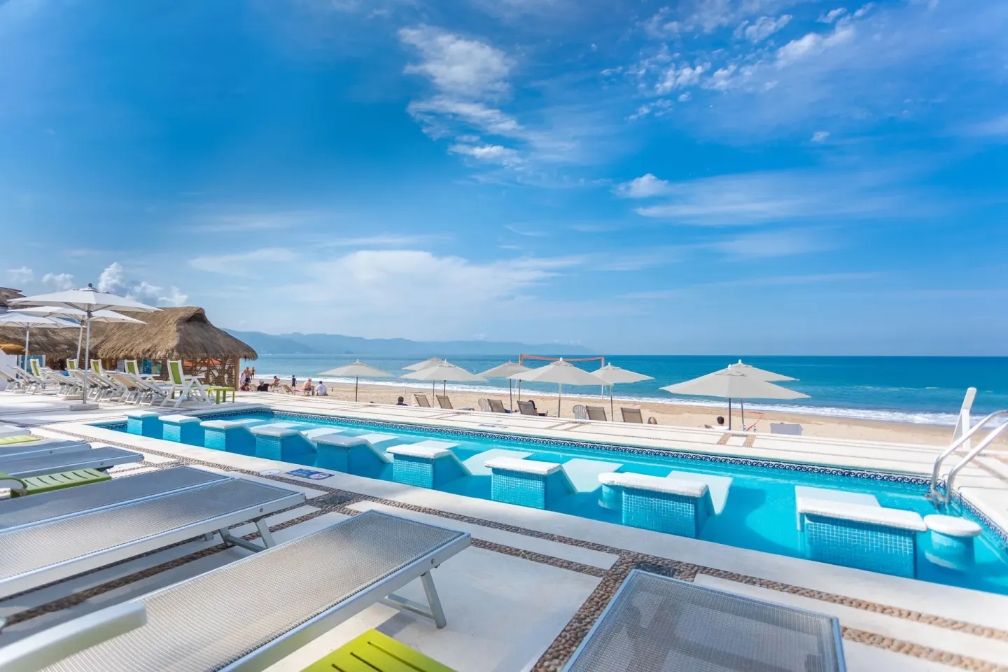 Beachfront pool at Buenaventura Grand Hotel & Great Moments with loungers, umbrellas, and ocean beyond.