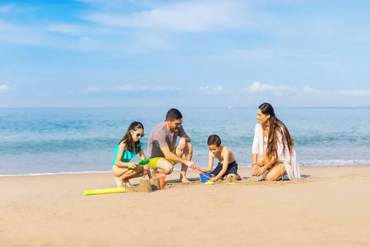 Family playing in the sand on the beach at Buenaventura Grand Hotel & Great Moments.