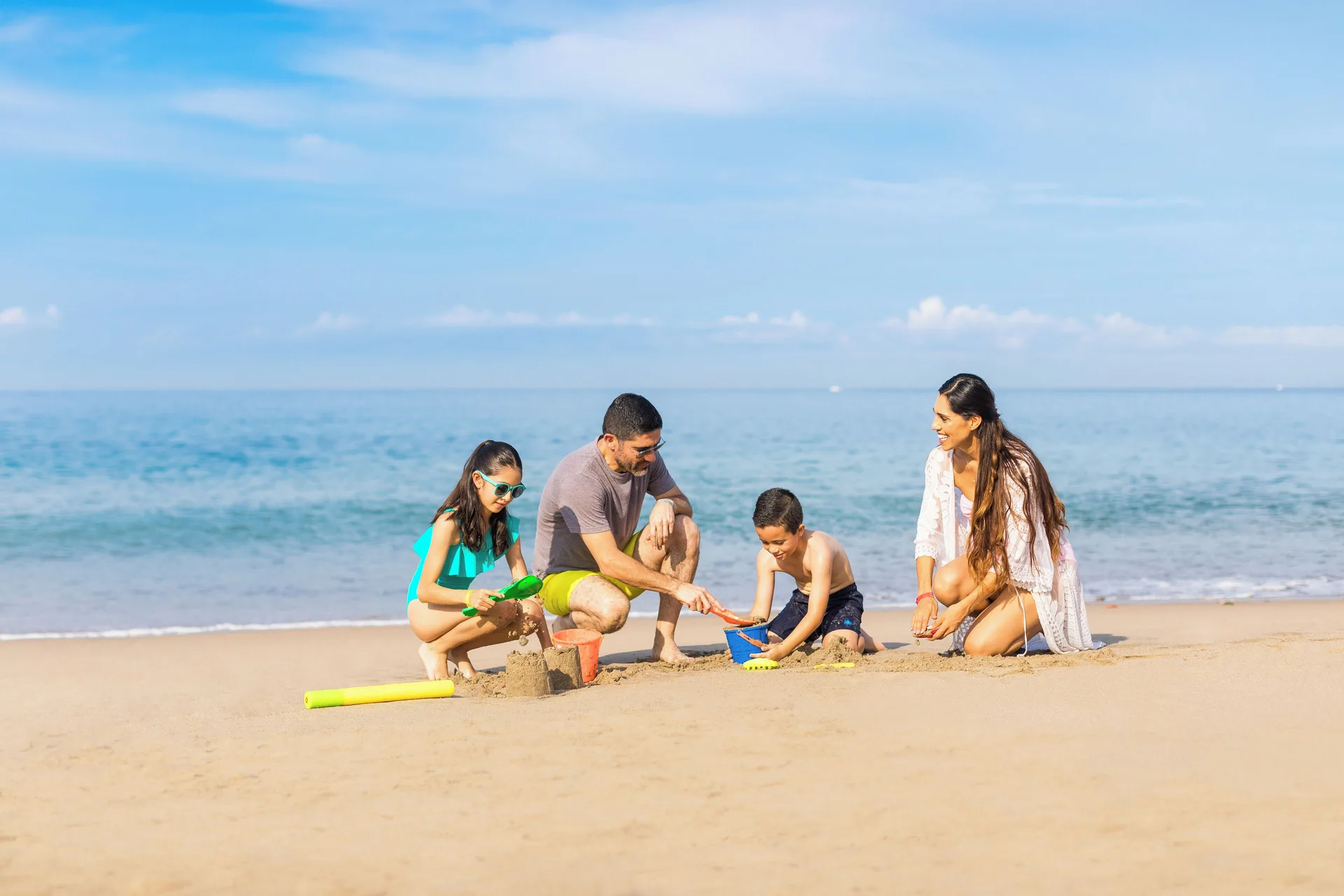 Family playing in the sand on the beach at Buenaventura Grand Hotel & Great Moments.