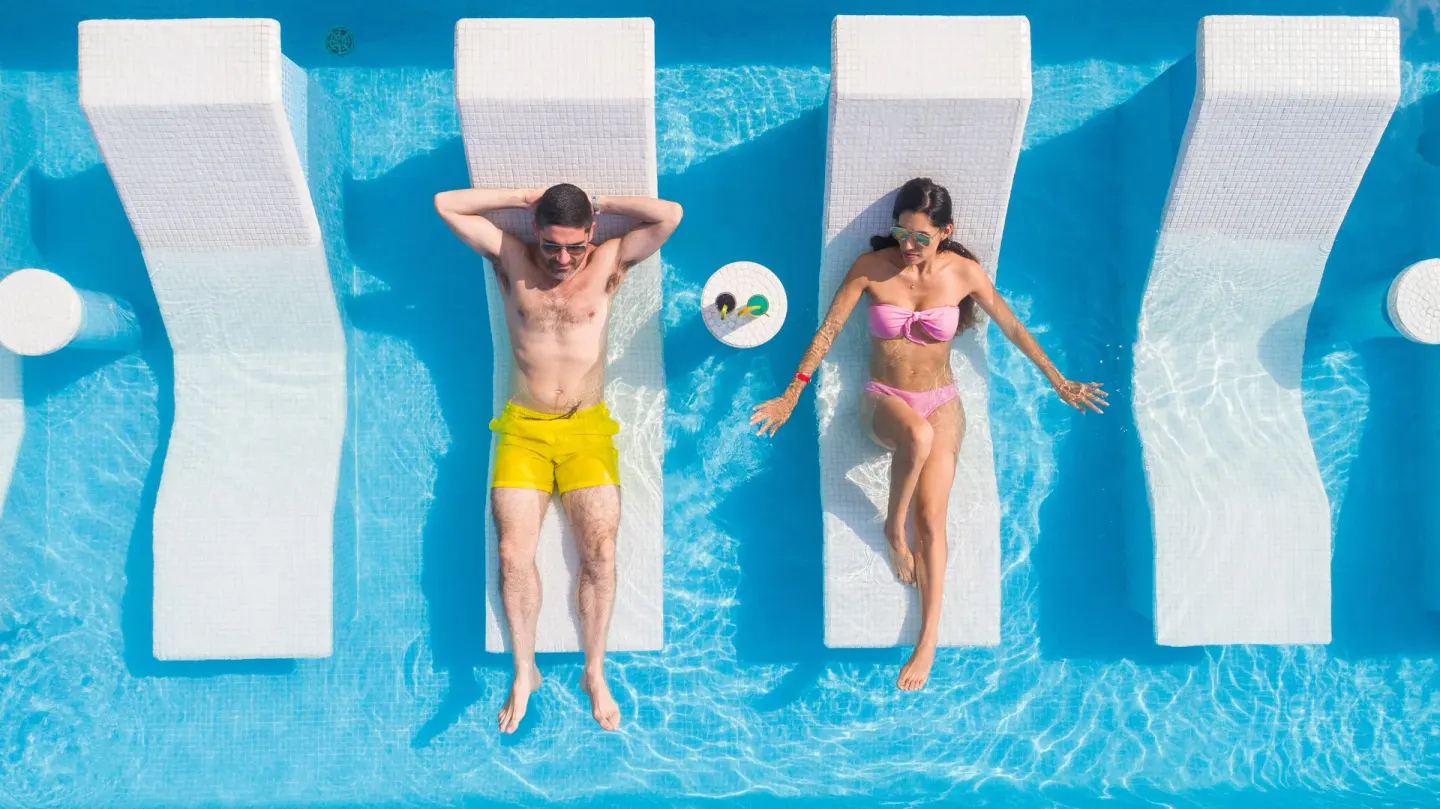 Guests reclining on in-pool loungers at Buenaventura Grand Hotel & Great Moments.