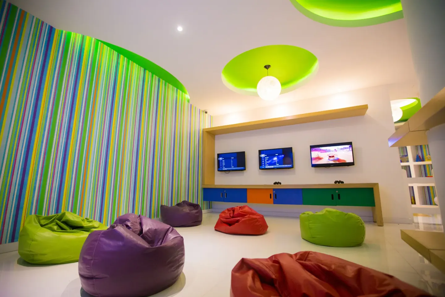 Colorful kids lounge with beanbags and gaming screens at Buenaventura Grand Hotel & Great Moments.