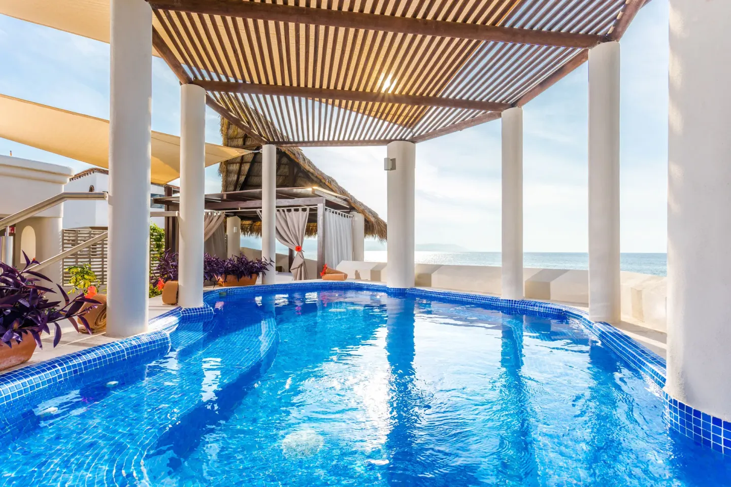 Shaded spa pool with white columns and ocean backdrop at Buenaventura Grand Hotel & Great Moments.
