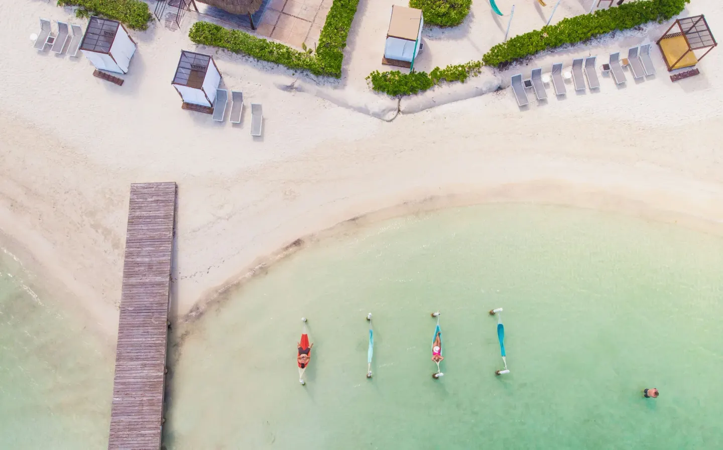 Aerial view of the beach, pier, loungers and shallow water at Cancun Bay Hotel.