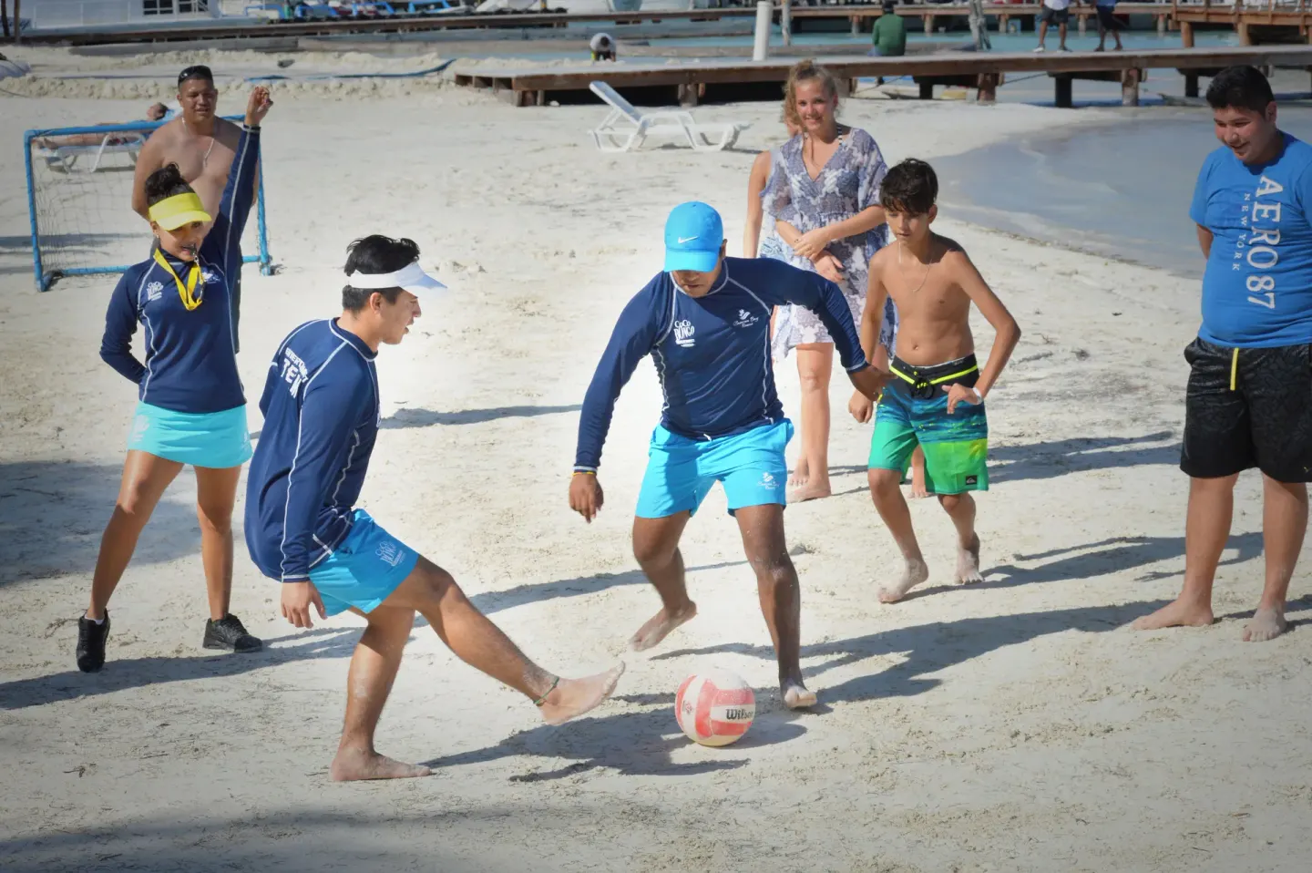 Guests and staff play soccer on the sandy beach at Cancun Bay Hotel.
