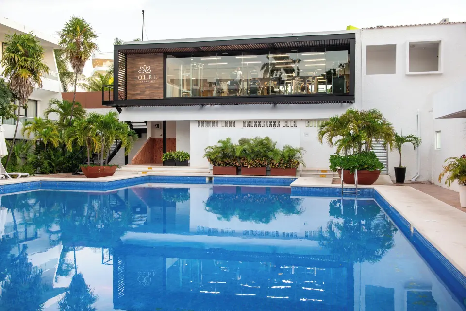 Pool courtyard with palms and an upper-level gym at Cancun Bay Hotel.