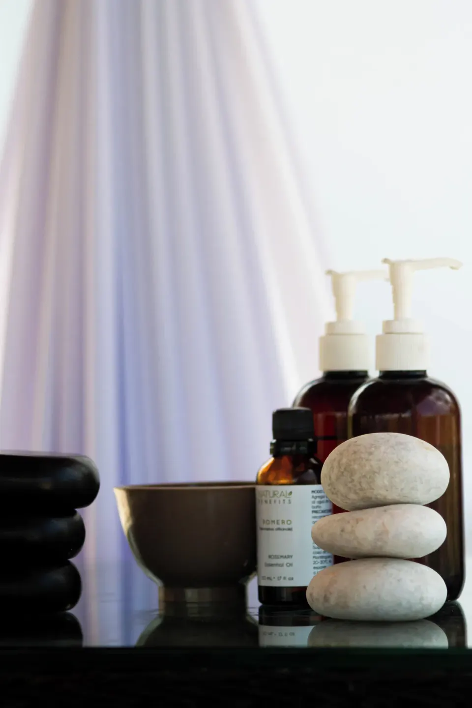 Spa stones, oils, and pump bottles arranged for a treatment at Cancun Bay Hotel.