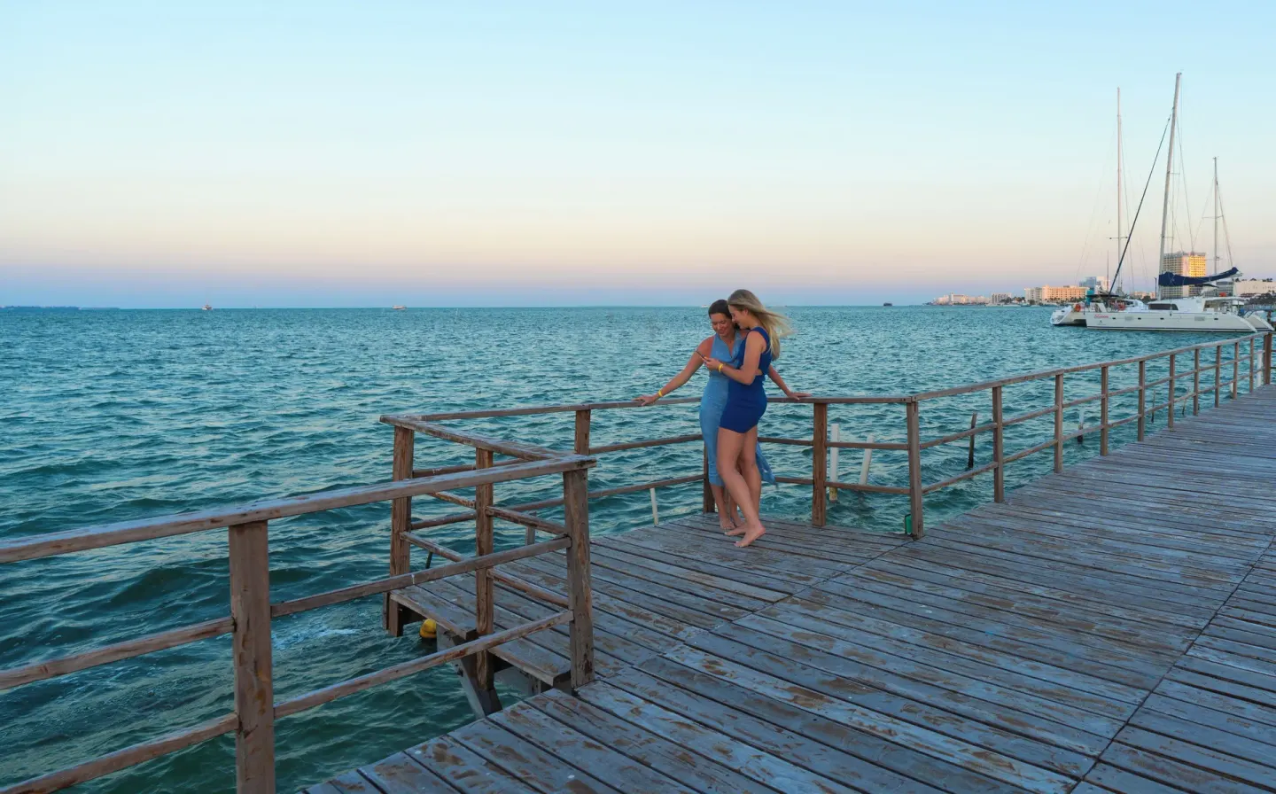 Guests stand on the wooden pier over the water at Cancun Bay Hotel.