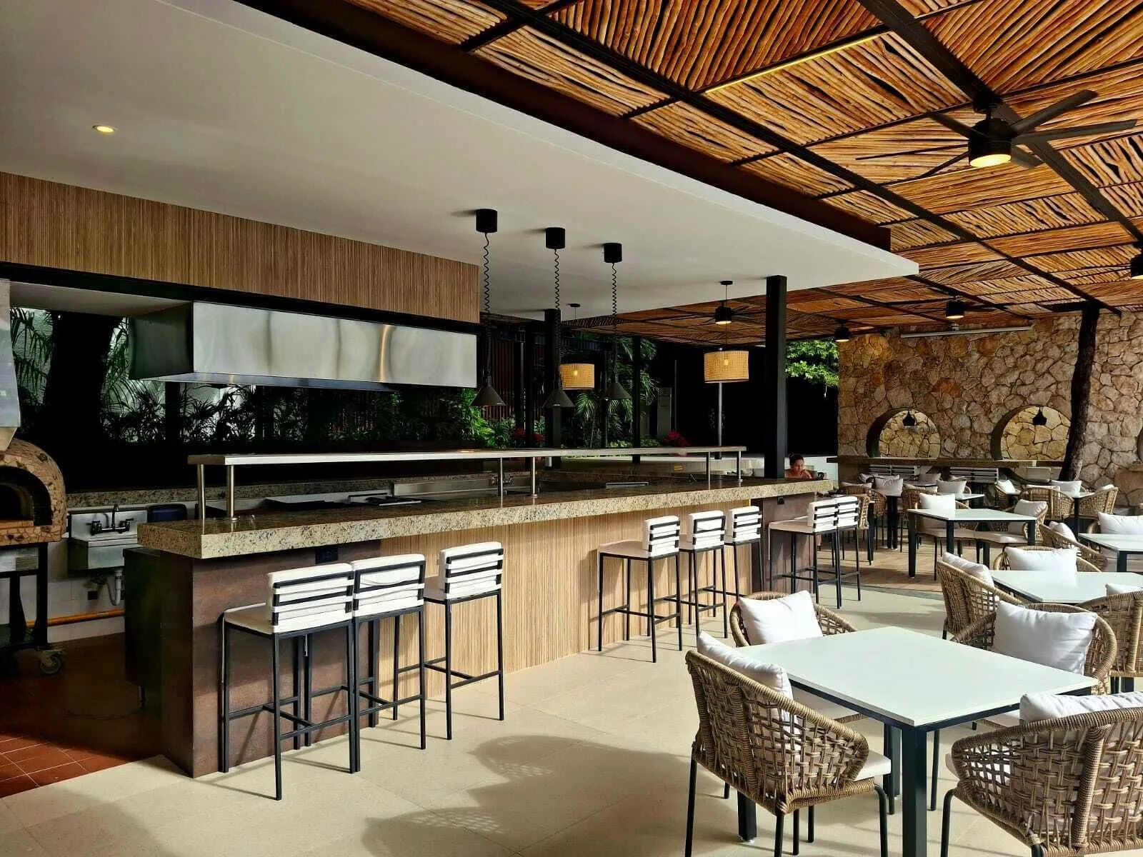 Covered restaurant patio with counter seating and wicker tables at Cancun Bay Hotel.