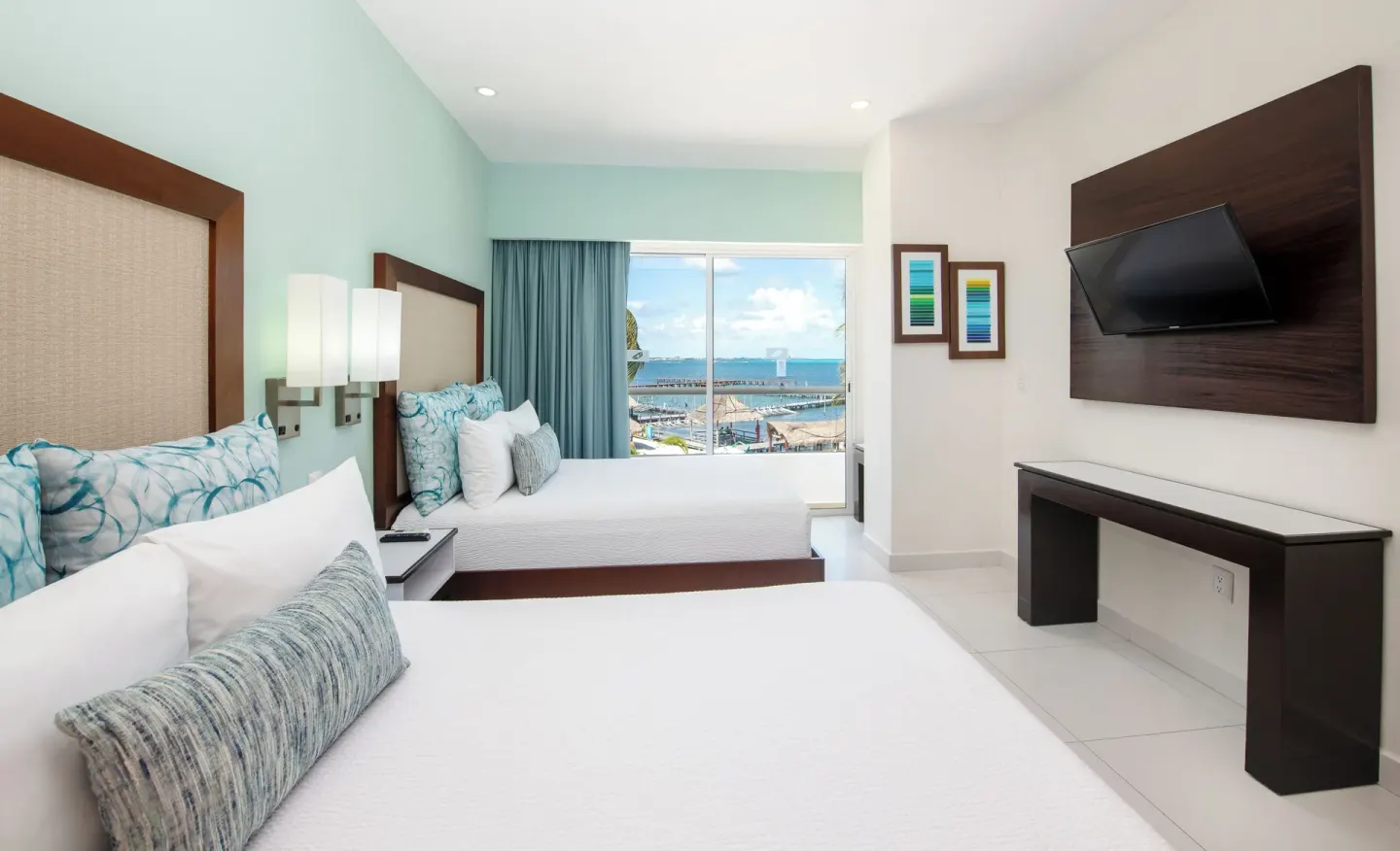 Master Suite 3 Bedrooms guest room with two beds, TV, desk, and sea-view window at Cancun Bay Hotel.