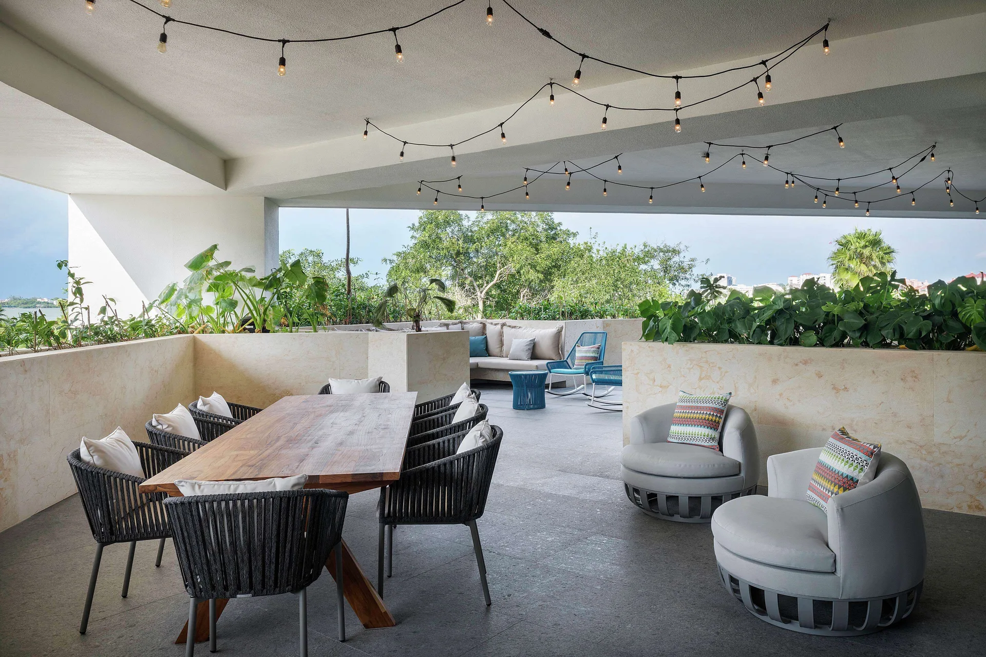 Covered terrace seating with plants and string lights at Canopy by Hilton Cancun La Isla.