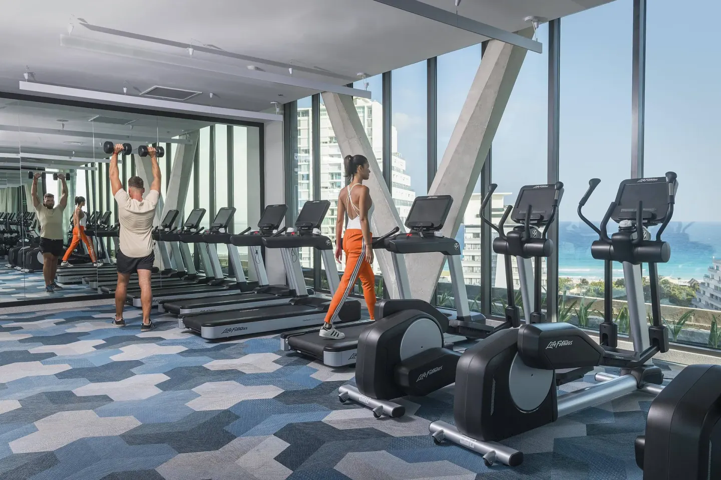 Fitness center with treadmills and ocean-facing windows at Canopy by Hilton Cancun La Isla.