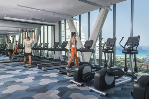 Fitness center with treadmills and ocean-facing windows at Canopy by Hilton Cancun La Isla.
