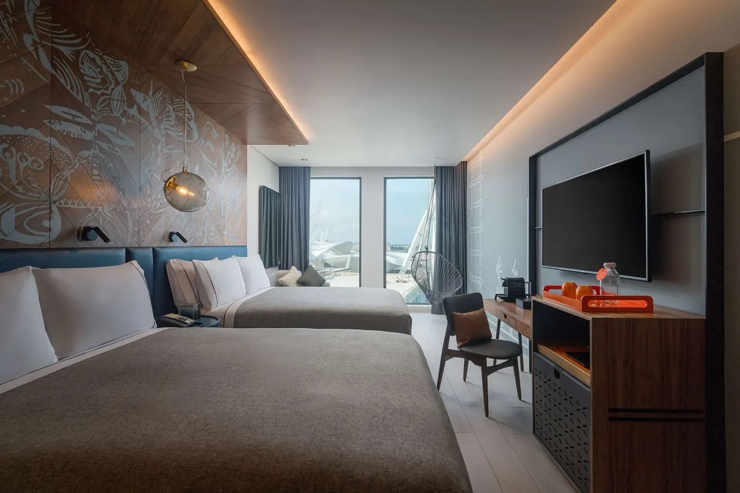 Two-bed guest room with desk, TV and window seating at Canopy by Hilton Cancun La Isla.