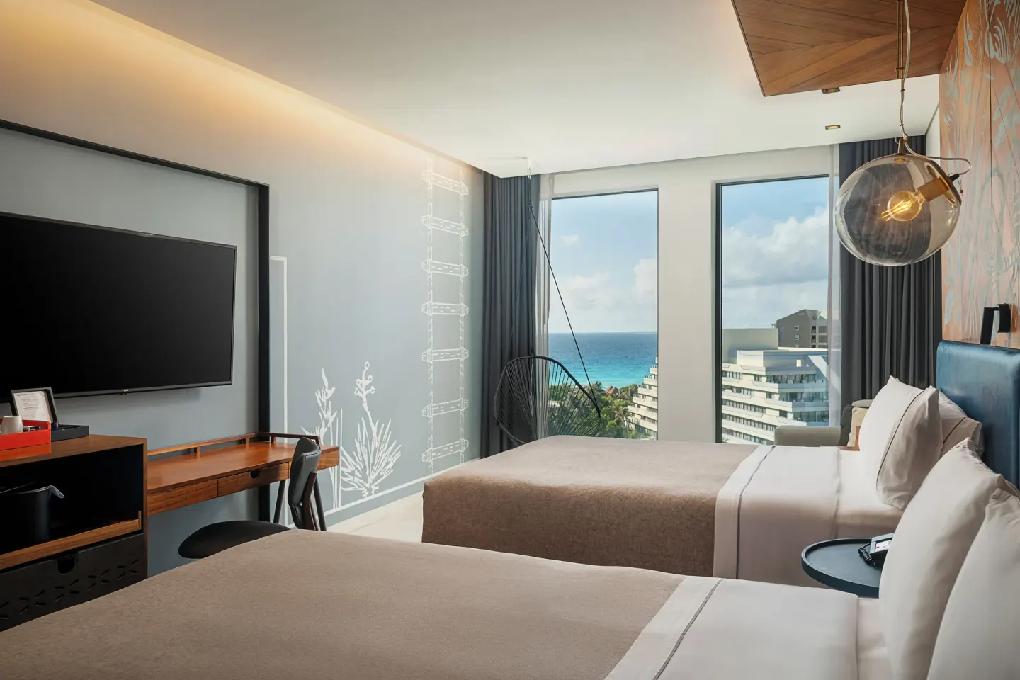 Two queen beds with ocean-facing windows at Canopy by Hilton Cancun La Isla.