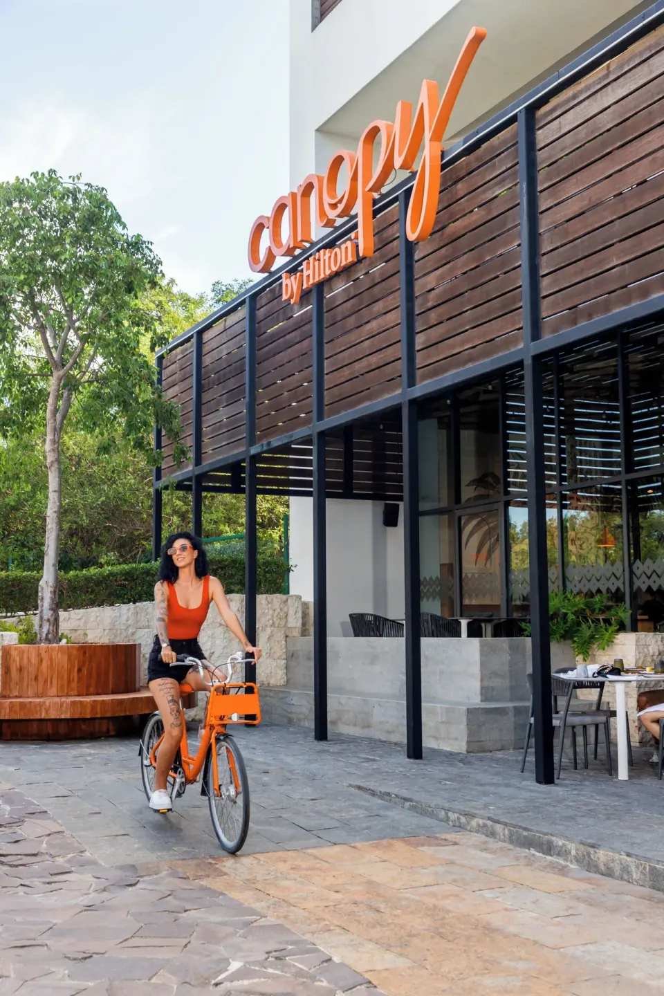 Hotel entrance with orange bicycle and Canopy signage at Canopy by Hilton Cancun La Isla.