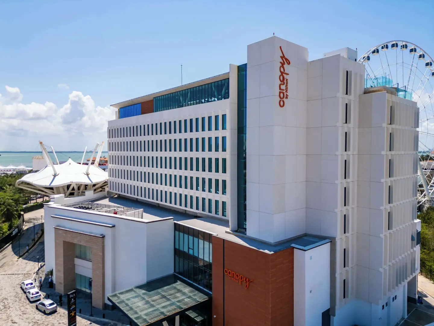 Exterior facade of Canopy by Hilton Cancun La Isla with Ferris wheel behind it.