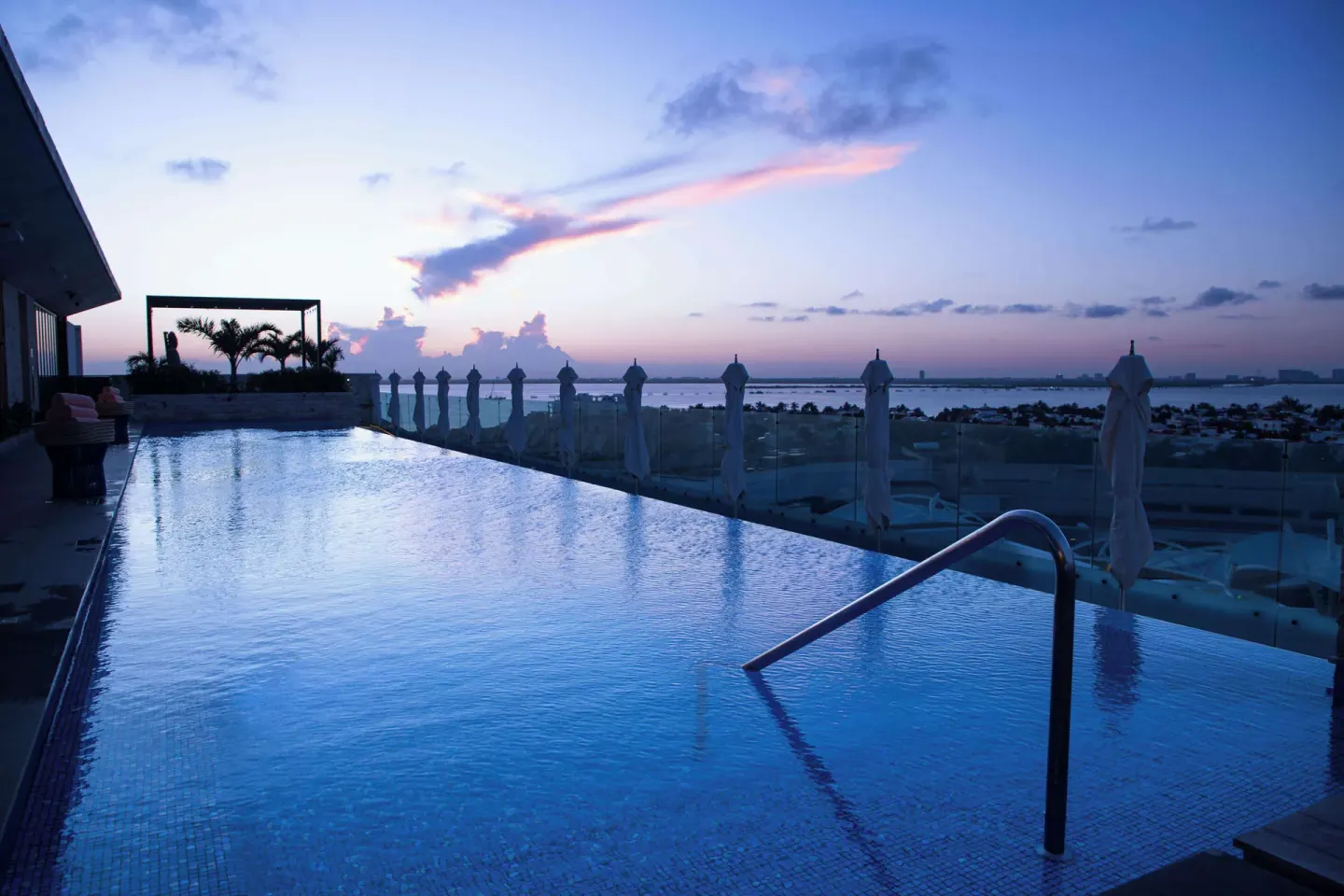 Infinity pool at sunset with lagoon view at Canopy by Hilton Cancun La Isla.