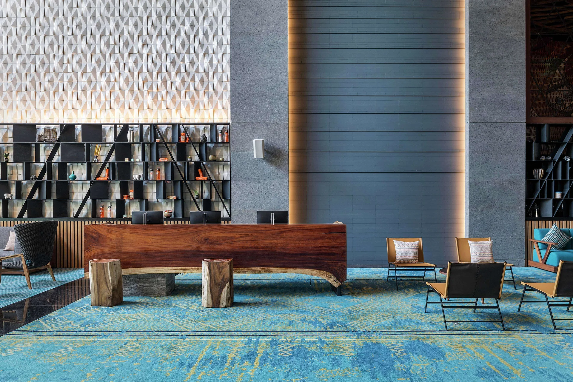 Reception desk with blue rug and lounge chairs at Canopy by Hilton Cancun La Isla.