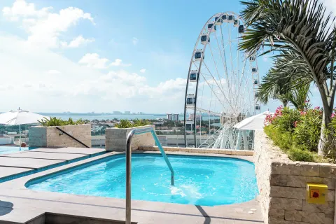Rooftop pool with Ferris wheel view at Canopy by Hilton Cancun La Isla.