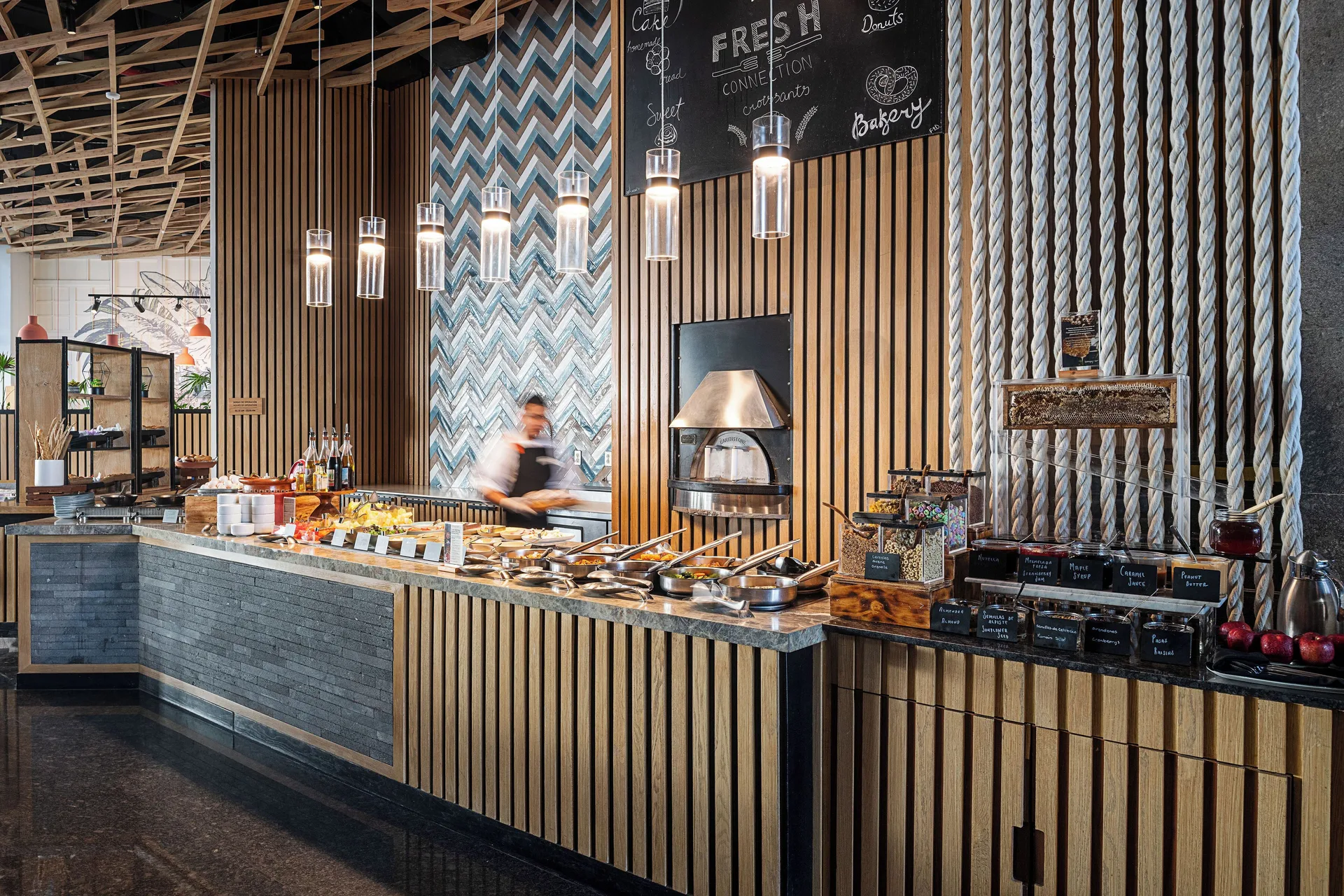 Breakfast buffet counter with pastries, condiments, and hot dishes at Canopy by Hilton Cancun La Isla.
