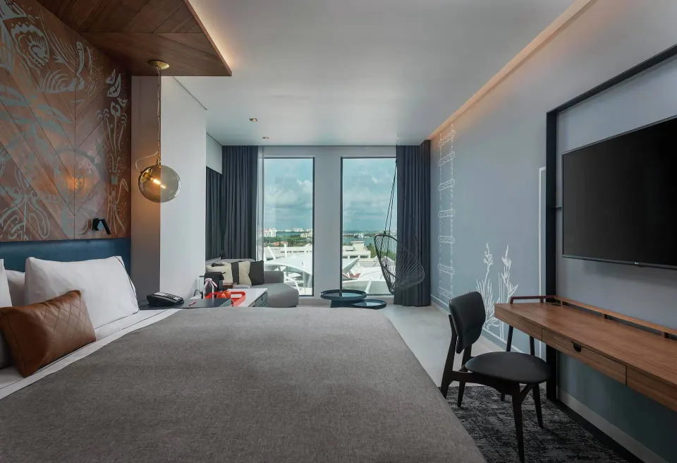 La Isla One Bed Room with king bed, desk and large windows at Canopy by Hilton Cancun La Isla.