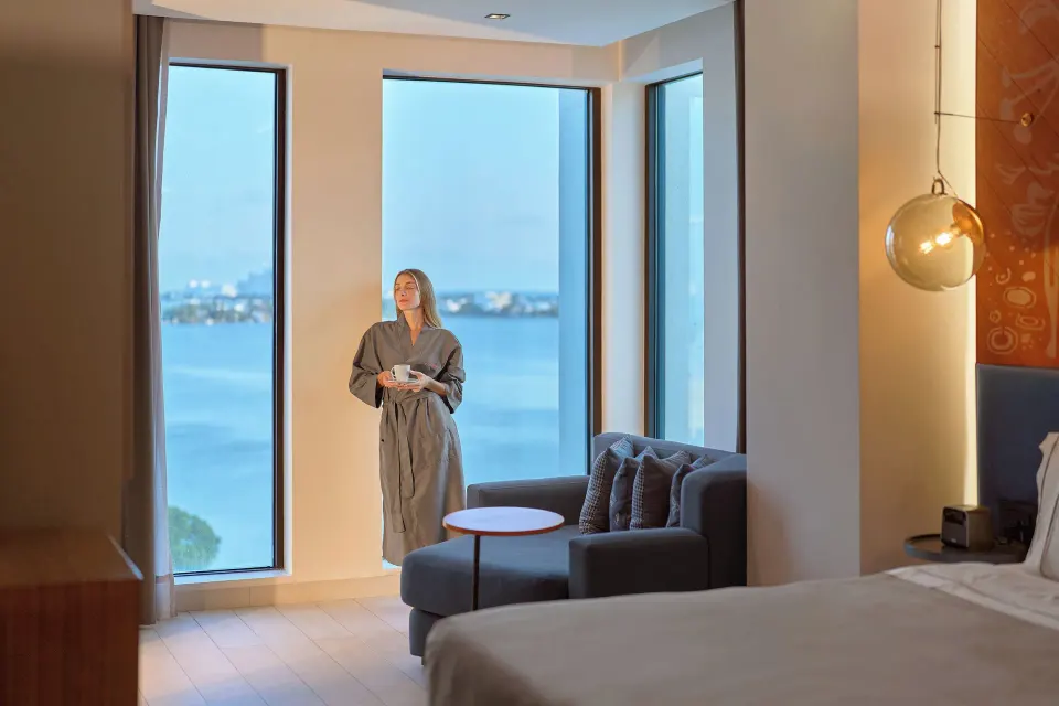 Presidential Suite bedroom seating by tall bay-view windows at Canopy by Hilton Cancun La Isla.