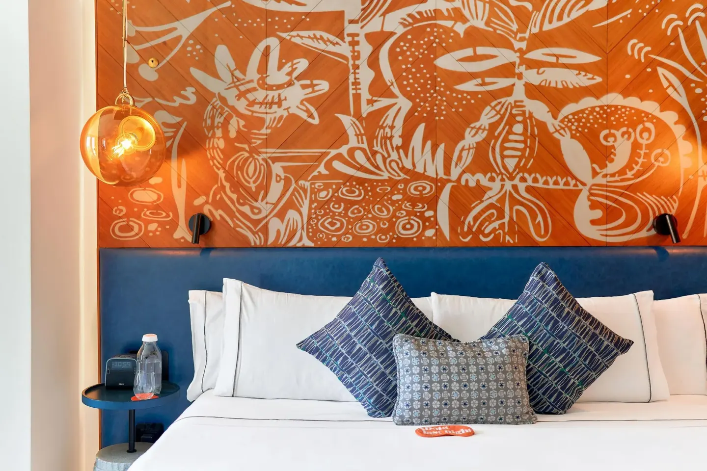 Presidential Suite king bed with orange mural headboard at Canopy by Hilton Cancun La Isla.