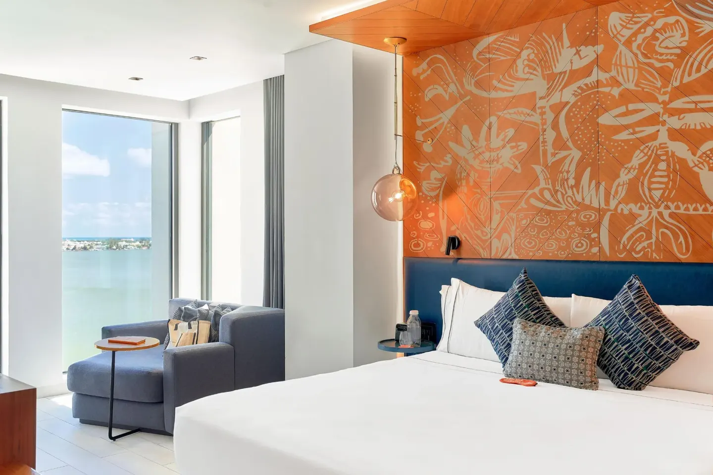 Presidential Suite king bed and bay-view sitting nook at Canopy by Hilton Cancun La Isla.