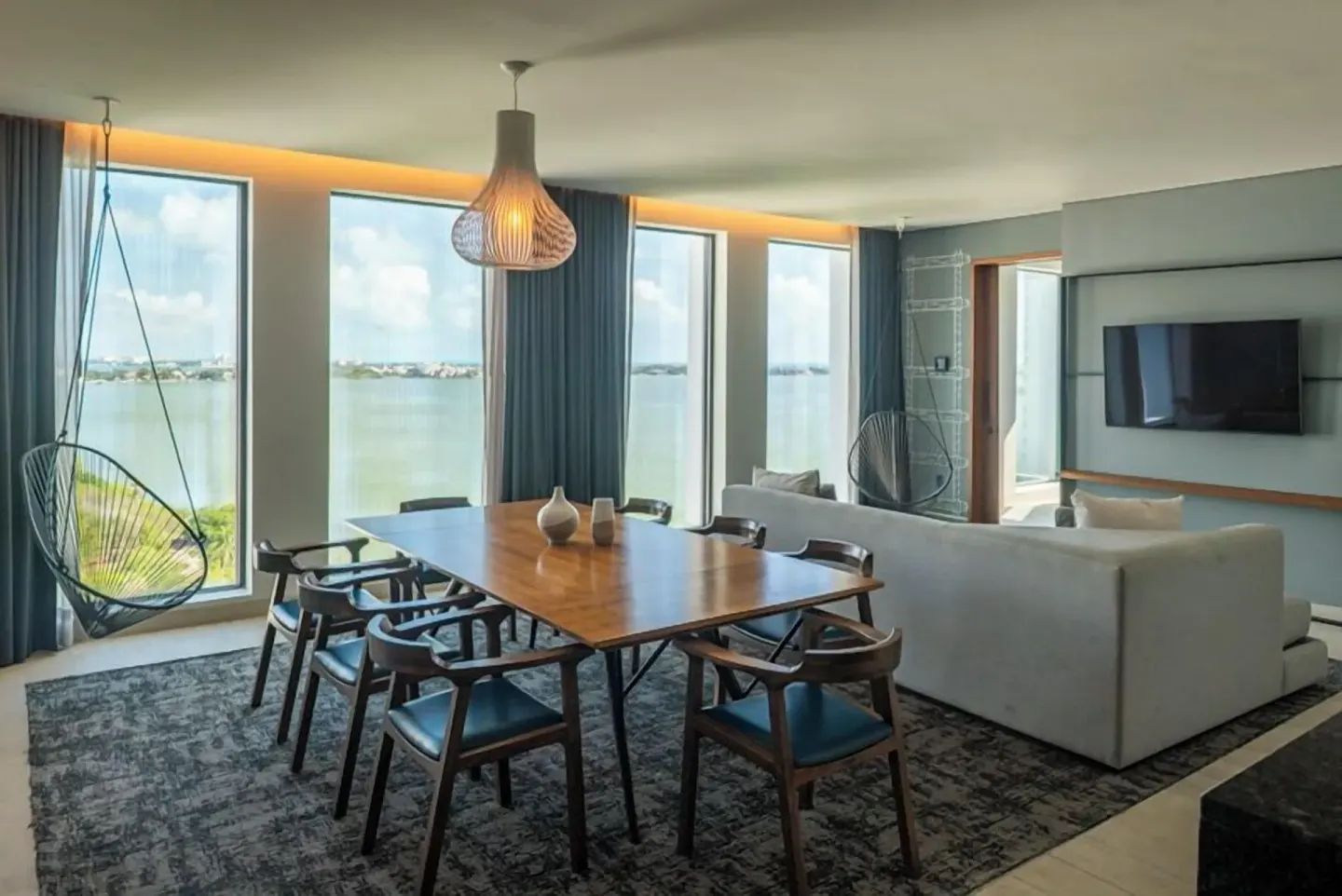 Presidential Suite living and dining area with bay windows at Canopy by Hilton Cancun La Isla.