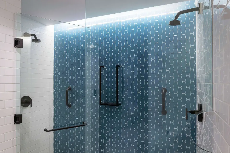 Roll-in shower with grab bars in an accessible room at Canopy by Hilton Cancun La Isla.