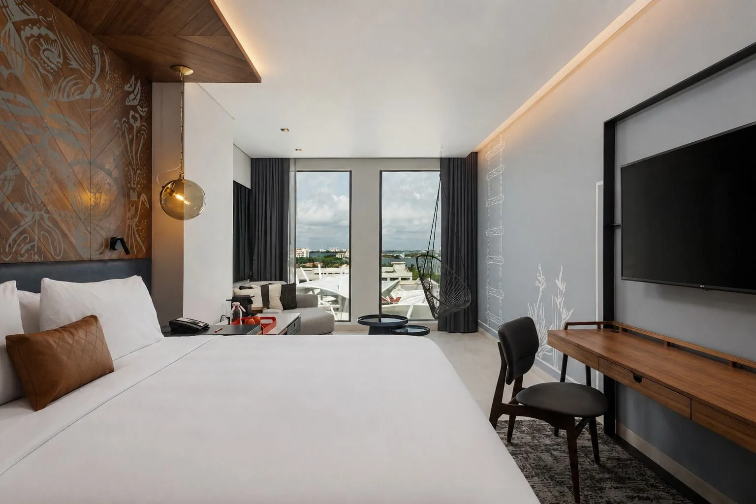 Signature Room king bed, desk, TV and balcony view at Canopy by Hilton Cancun La Isla.