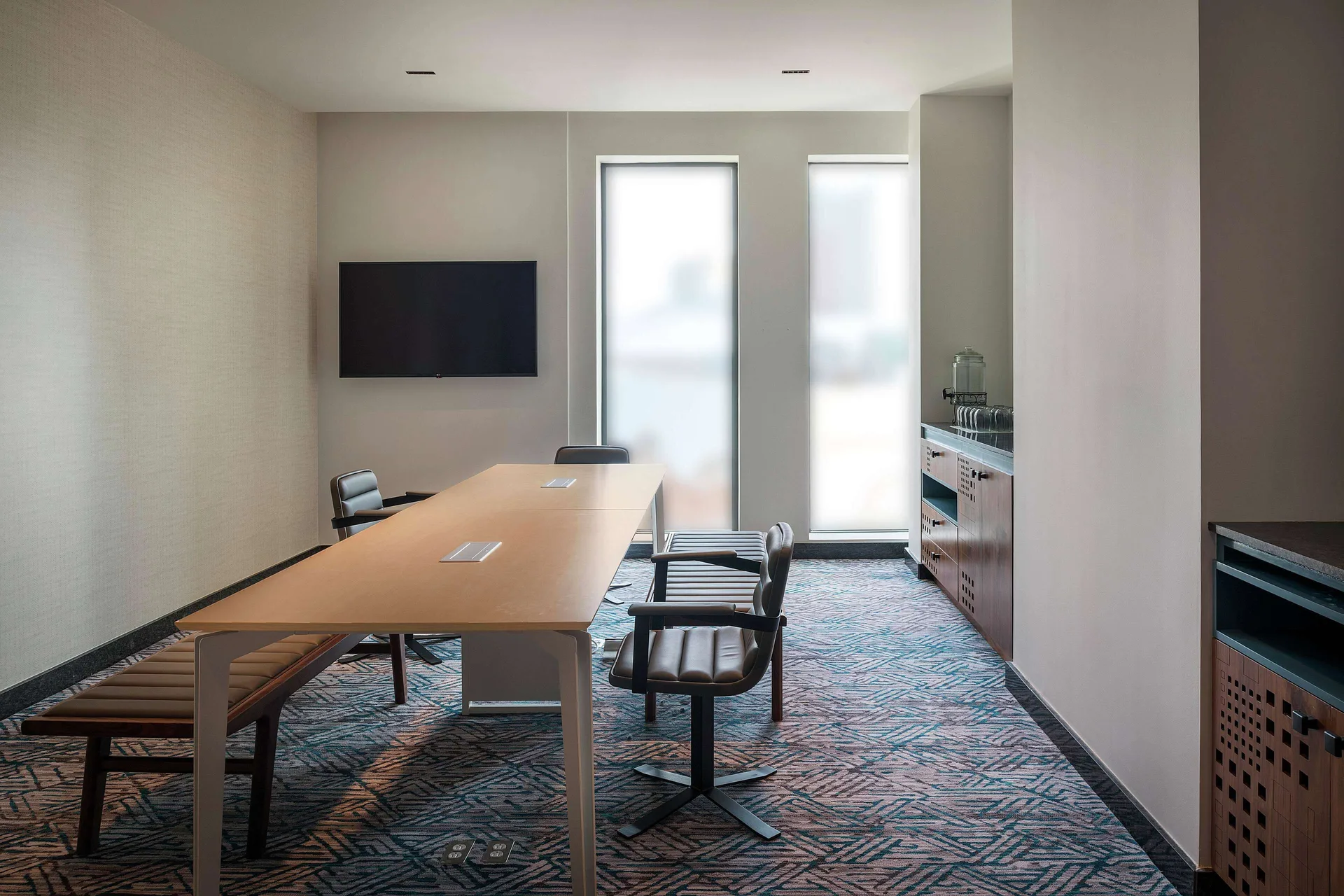 Boardroom table with wall screen and service counter at Canopy by Hilton Cancun La Isla.