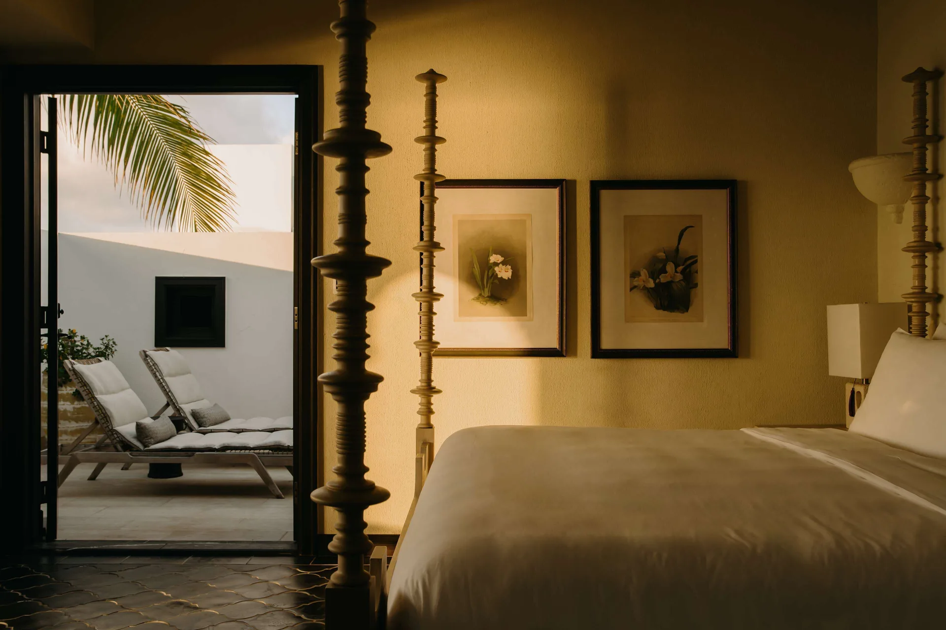 Guest room bed opening to a private patio with loungers at Cap Juluca, Anguilla.