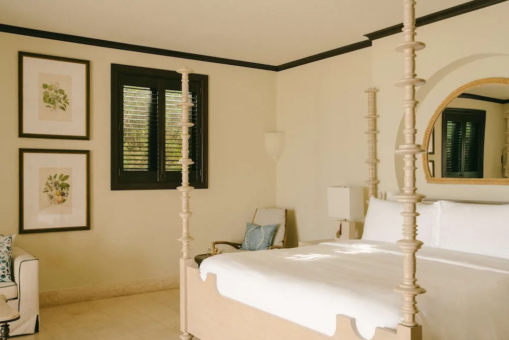Four-poster king bed with shutters and botanical art at Cap Juluca, Anguilla.