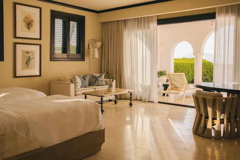 Guest room with terrace doors, seating, and bed at Cap Juluca, Anguilla.